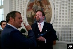 Conservative radio host Sebastian Gorka, right, speaks with White House correspondent for Playboy magazine Brian Karem, after President Donald Trump spoke about the 2020 census in the Rose Garden of the White House, in Washington, July 11, 2019.