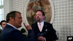 FILE - Conservative radio host Sebastian Gorka, right, speaks with White House correspondent for Playboy magazine Brian Karem, after President Donald Trump spoke about the 2020 census in the Rose Garden of the White House, in Washington, July 11, 2019.