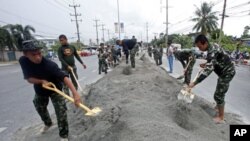 Soldiers make a bank along a street to prepare in case of more flooding in Pathum Thani province, on the outskirts of Bangkok, Thailand, October 12, 2011.