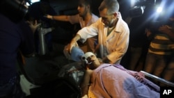 Palestinian medics transport a wounded boy after an Israeli air strike targeted a motorcycle to Kamal Adwan hospital, in the northern Gaza Strip town of Beit Lahiya, northern Gaza Strip, June 11, 2014. 