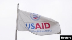 FILE - A USAID flag flutters outside as the USAID building sits closed to employees after a memo was issued freezing funding, in Washington, Feb. 3, 2025.