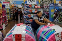 FILE - Balo Balogun labels items in preparation for a holiday sale at a Walmart Supercenter, Nov. 27, 2019, in Las Vegas.