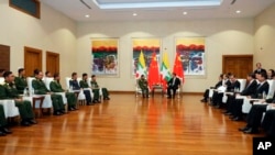 In this photo released by Office of the Commander in Chief of Defense Services, Myanmar's Army Commander Senior Gen. Min Aung Hlaing, center left, speaks with Chinese President Xi Jinping, center right, at a hotel in Naypyitaw, Myanmar, Jan. 18, 2020.