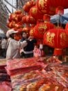 People shop for decorations at a market in Fuyang, in China’s eastern Anhui Province, Jan. 22, 2025, in the buildup to celebrations of the Lunar New Year. Many Chinese are cutting back on Spring Festival expenses because of the stressed economy.