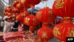 People shop for decorations at a market in Fuyang, in China’s eastern Anhui Province, Jan. 22, 2025, in the buildup to celebrations of the Lunar New Year. Many Chinese are cutting back on Spring Festival expenses because of the stressed economy.