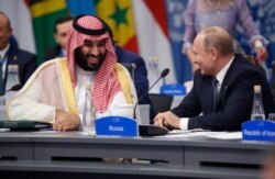 FILE - Saudi Arabia's Crown Prince Mohammed bin Salman talks with Russian President Vladimir Putin during a G-20 session with other heads of state, in Buenos Aires, Argentina, Nov. 30, 2018.