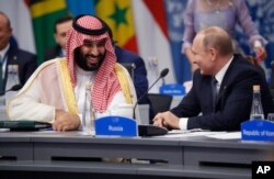 FILE - Saudi Arabia's Crown Prince Mohammed bin Salman talks with Russian President Vladimir Putin during a G-20 session with other heads of state, in Buenos Aires, Argentina, Nov. 30, 2018.