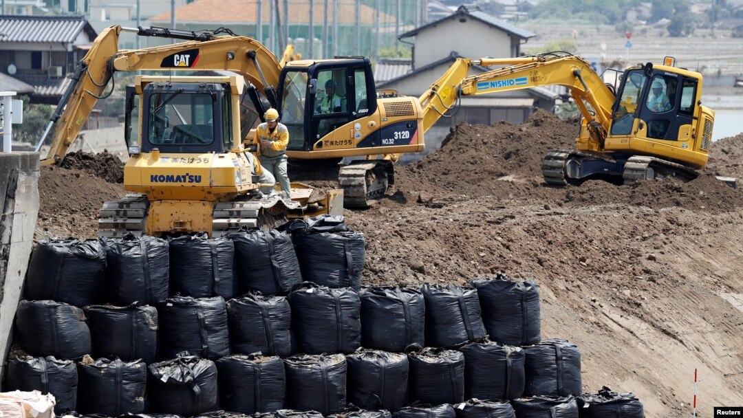 Workers conduct repair work on the destroyed embankment along Odagawa river in Mabi town in Kurashiki, Okayama Prefecture, Japan, July 13, 2018. The nation is preparing for more disastrous weather with the arrival of a typhoon.