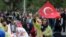 Women wave national flags as they listen to Ahmet Davutoglu, Turkey's Prime Minister and the leader of Justice and Development Party, AKP, during a rally ahead of Sunday general elections, in Diyarbakir, Turkey, Thursday, Oct. 29, 2015.
