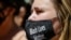 A women wears a protective mask as she joins protesters near Trump Tower as part of a solidarity rally calling for justice over the death of George Floyd, and to highlight police brutality nationwide, June 12, 2020, in New York.