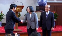 In this image made from video, Taiwan's outgoing Premier Lai Ching-te, left, shakes hands with President Tsai Ing-wen, center, as newly appointed Premier Su Tseng-chang, right, looks on after a press conference at the presidential office in Taipei, T