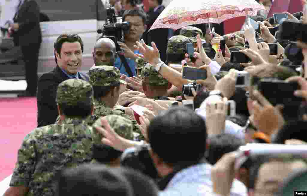 美国影星約翰・特拉沃塔 （John Travolta）参加万达集团在青岛投资建设的，全球投资规模最大的影视产业基地――青岛东方影都的推广活动，和影迷握手（2013年9月22日）。