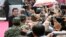 American actor John Travolta (L) shakes hands with fans as he arrives for the launch ceremony of the Qingdao Oriental Movie Metropolis on the outskirts of Qingdao, China, September 22, 2013.