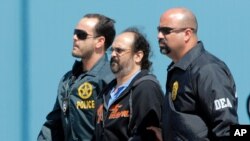 El paramilitar colombiano Rodrigo Tovar Pupo es escoltado por agentes de la DEA de Estados Unidos en esta foto de archivo el 6 de octubre de 2015.