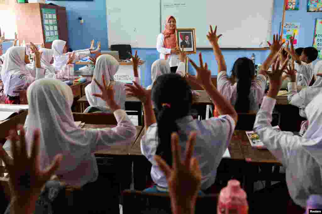 A teacher shows a portrait of Indonesia&#39;s new President Prabowo Subianto as she teaches and introduces the eighth president of the country, at the Pondok Labu Elementary School 14 Pagi, in Jakarta.