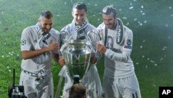 Le trio Karim Benzema, Cristiano Ronaldo et Gareth Bale du Real Madrid posent pour une photo avec le trophée de la Ligue des Champions au stade Santiago Bernabeu à Madrid, 29 mai 2016. 