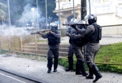 Military police fire the shotguns at demonstrators during a protest against crimes committed by the police against black people in the favelas, outside the Rio de Janeiro's state government, Brazil, Sunday, May 31, 2020.