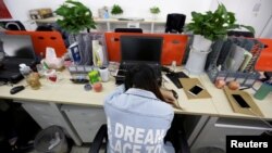 Yang Juan, karyawan Goopal Group di Beijing, China, tidur siang di kursinya setelah makan siang, 21 April 2016. (REUTERS/Jason Lee)