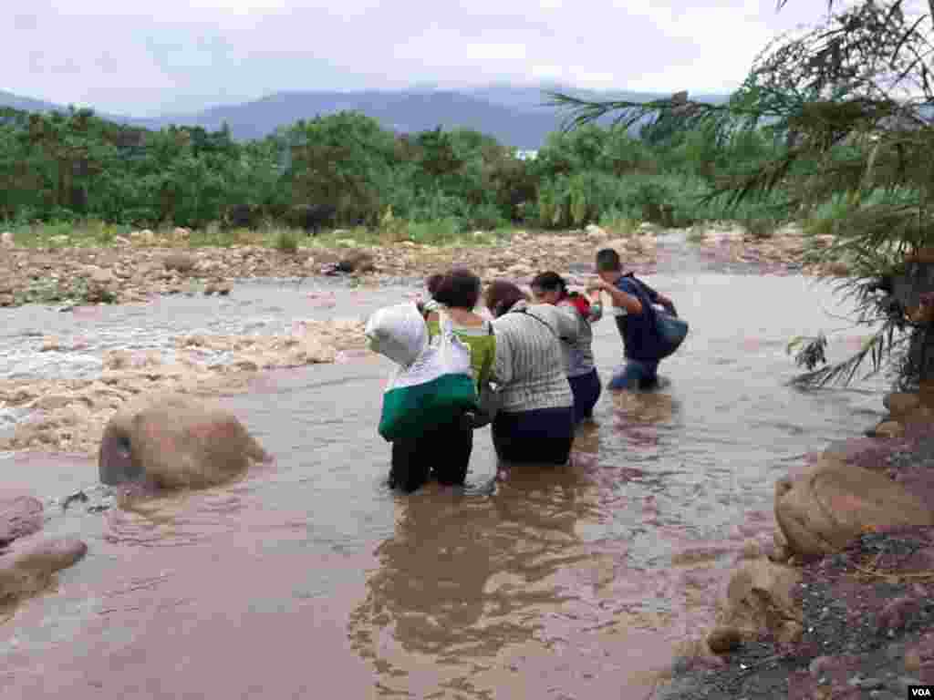 Migrantes cruzando una de las trochas fronterizas entre Colombia y Venezuela.