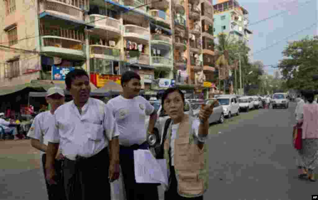 A Myanmar census enumerator and volunteers walk in a Muslim neighborhood collecting information in Yangon, Myanmar, Sunday, Mar 30, 2014. Enumerators fanned out across Myanmar on Sunday for a census that has been widely criticized for stoking religious an