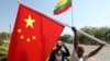 FILE - Workers put up flags a day before Chinese President Xi Jinping's visit to Myanmar in Naypyitaw, Myanmar, January 16, 2020. 