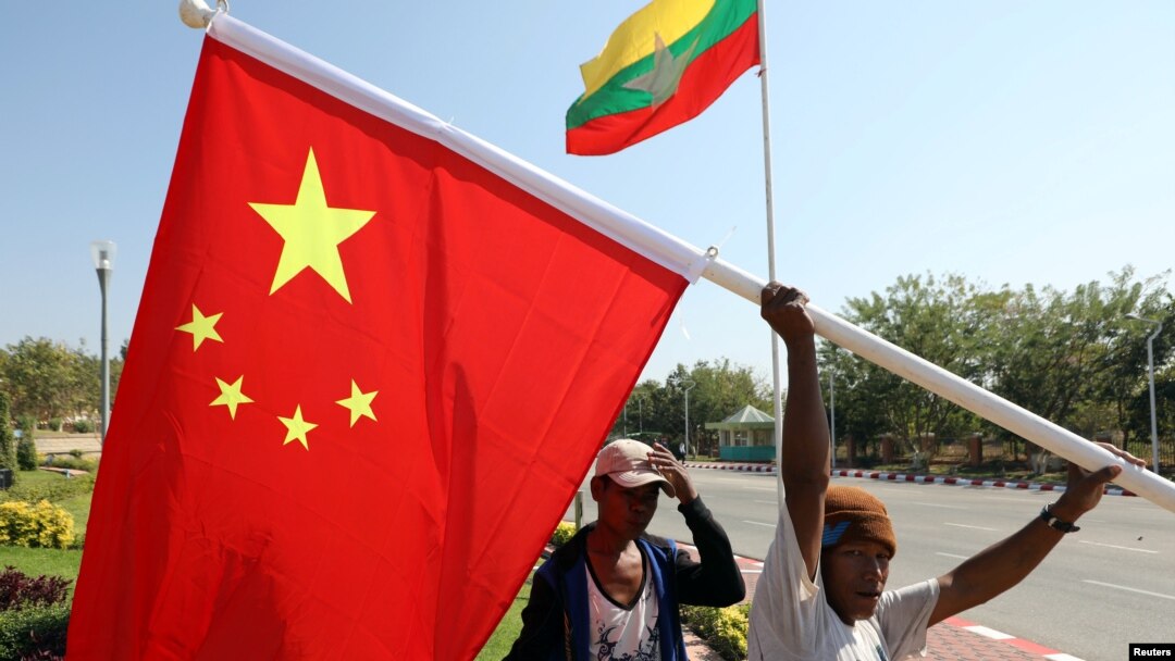 FILE - Workers put up flags a day before Chinese President Xi Jinping's visit to Myanmar in Naypyitaw, Myanmar, January 16, 2020. 