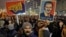 People hold posters depicting the leader of the ruling Social Democratic party, Liviu Dragnea, the other reading "Romania-Wake Up" during a protest in Bucharest, Romania, Feb. 1, 2017.