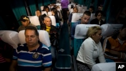 Cuban migrants wait on a bus in Ciudad Pedro De Alvarado, Guatemala, at the border with El Salvador, Wednesday, Jan. 13, 2016, as they continue on their journey to the United States. After more than three months stranded in Costa Rica, 180 of the 8,000 Cuban migrants were flown to El Salvador, and then traveled by land to Guatemala as part of a regional agreement to overcome Nicaragua's refusal to let them through by land.