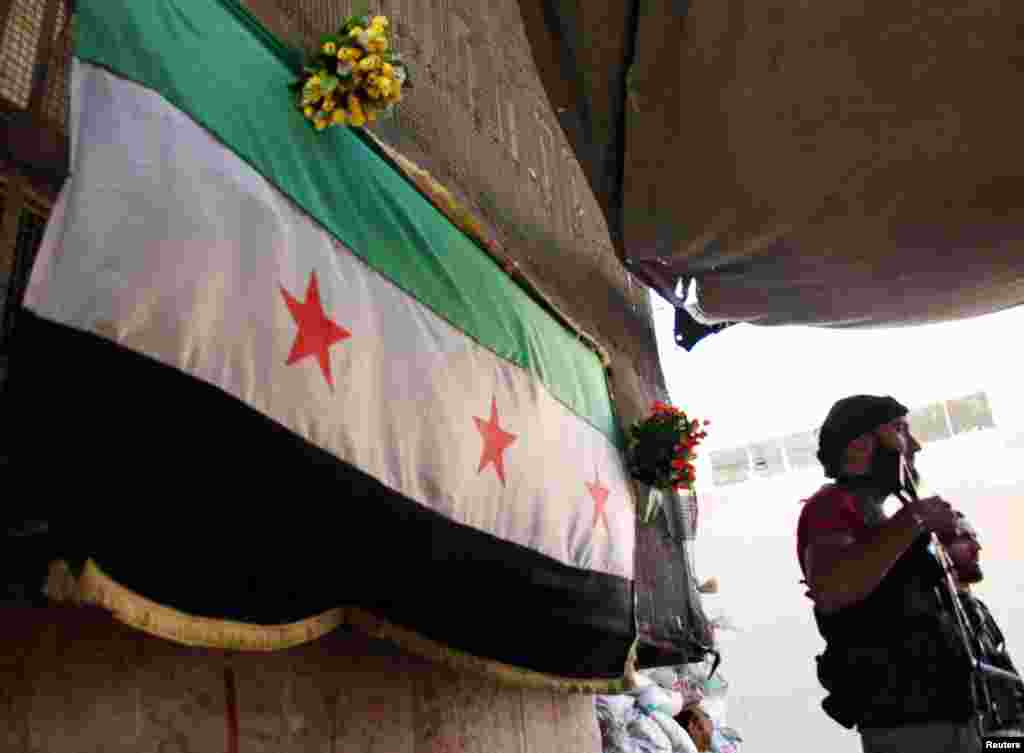 Free Syrian Army fighters hold weapons at their post in Aleppo's Bustan al-Qasr neighborhood, May 29, 2013.