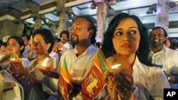 Sri Lankan performing artists hold national flags and lamps as they stage a peaceful protest against a UN report that gives credence to allegations the government and Tamil Tiger rebels may have committed war crimes as the country's civil war drew to a cl