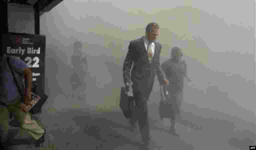 FILE - In this Tuesday, Sept. 11, 2001 file photo, pedestrians flee the dust-filled area surrounding the World Trade Center following a terrorist attack on the New York landmark. (AP Photo/Amy Sancetta)