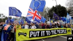 Demonstrators hold a banner during a Peoples Vote anti-Brexit march in London, March 23, 2019.