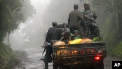 Congolese M23 rebels carry goods in the back of a truck near the Congo-Uganda border town of Bunagana, DRC. (file)