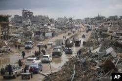 FILE - Cars and pedestrians move along a road amid widespread destruction caused by the Israeli military's ground and air offensive against Hamas in Gaza City's Jabaliya refugee camp, Feb. 7, 2025.