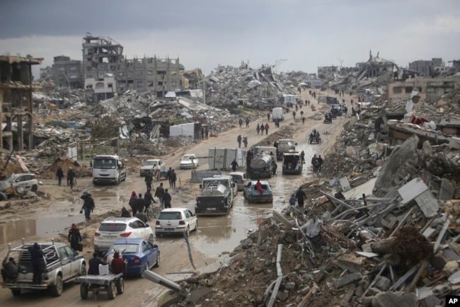 FILE - Cars and pedestrians move along a road amid widespread destruction caused by the Israeli military's ground and air offensive against Hamas in Gaza City's Jabaliya refugee camp, Feb. 7, 2025.