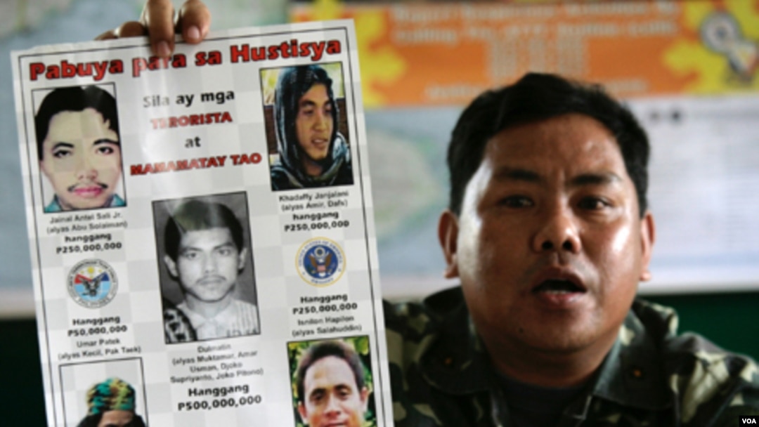 Dalam foto dari tahun 2006 ini, Pejabat militer Filipina Mayor Mabini Abduhadi menunjukkan poster bergambar tokoh Al-Qaida yang diduga terkait dengan gerakan MILF, termasuk Umar Patek (kiri bawah).