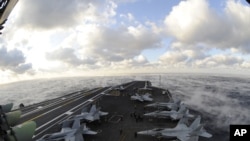 Fog rises over the Atlantic Ocean as the aircraft carrier USS Dwight D. Eisenhower conducts flight operations, 4 Jan 2010