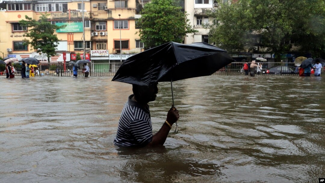 A man wades through a waterlogged street following heavy rains in Mumbai, India, Aug. 29, 2017.