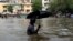 A man wades through a waterlogged street following heavy rains in Mumbai, India, Aug. 29, 2017.