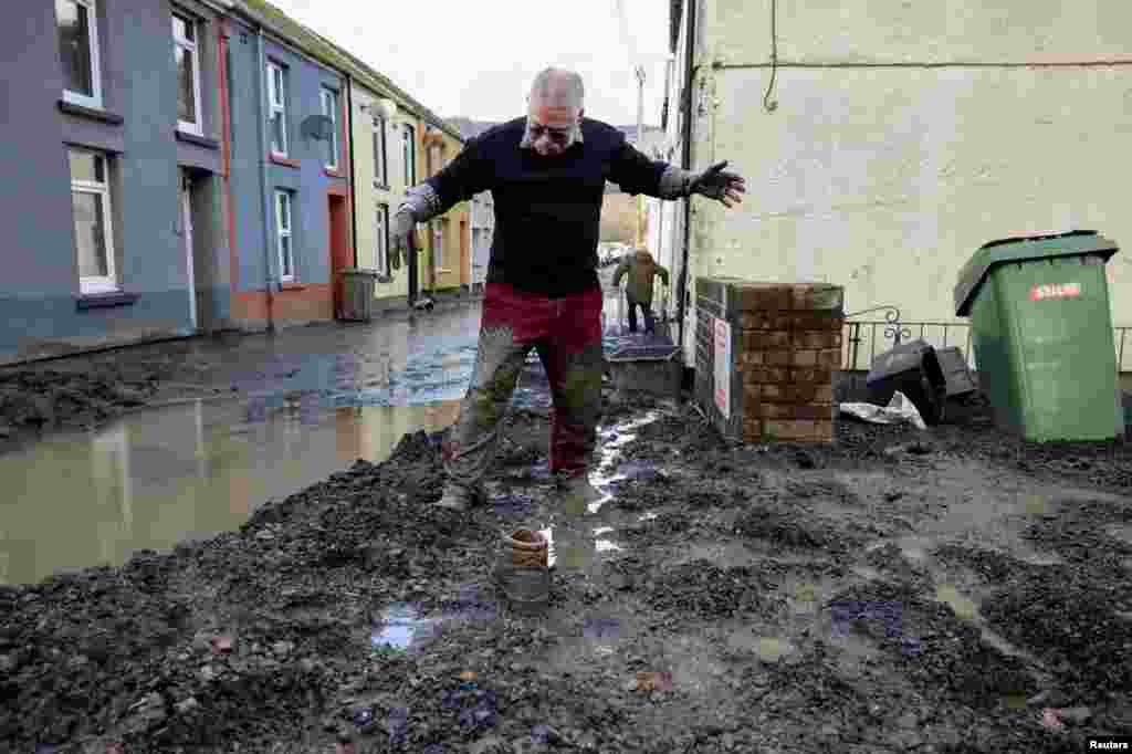 Resident Rob Scholes, 75, walks through mud at the site of a mudslide, in the aftermath of Storm Bert, in Cwmtillery, South Wales, Britain.