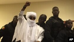 FILE - Chad's former dictator Hissene Habre raises his hand during court proceedings in Dakar, Senegal, May 30, 2016. 