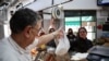 Butcher Dario Barrandeguy gives an order of meat to a customer at his shop, in Buenos Aires, Argentina June 10, 2024. Inflation has hit Argentines hard.