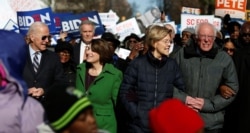 Seven of the Democratic US Presidential candidates including former U.S. Vice President Joe Biden, Sen. Amy Klobuchar, Sen. Elizabeth Warren and Sen. Bernie Sanders, walk arm-in-arm with local African-American leaders during the Martin Luther King…