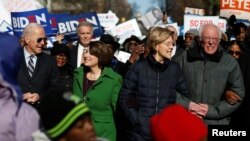FILE - Democratic presidential candidates walk with local African American leaders during the Martin Luther King Jr. Day Parade in Columbia, S.C., Jan. 20, 2020. More racially diverse electorates await candidates in South Carolina and Nevada.