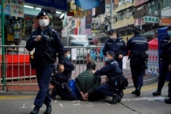 A man who sought to enter the closed area in Hong Kong's Jordan District is detained after attacking a police officer, Jan. 23, 2021. Thousands of Hong Kongers were locked down Saturday in a bid to contain a worsening coronavirus outbreak.