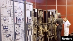 FILE - Employees of a Russian nuclear research centre, the Kurchatov Institute, are seen through the window of a laboratory during a tour of the centre in Moscow, Oct. 24, 2006.