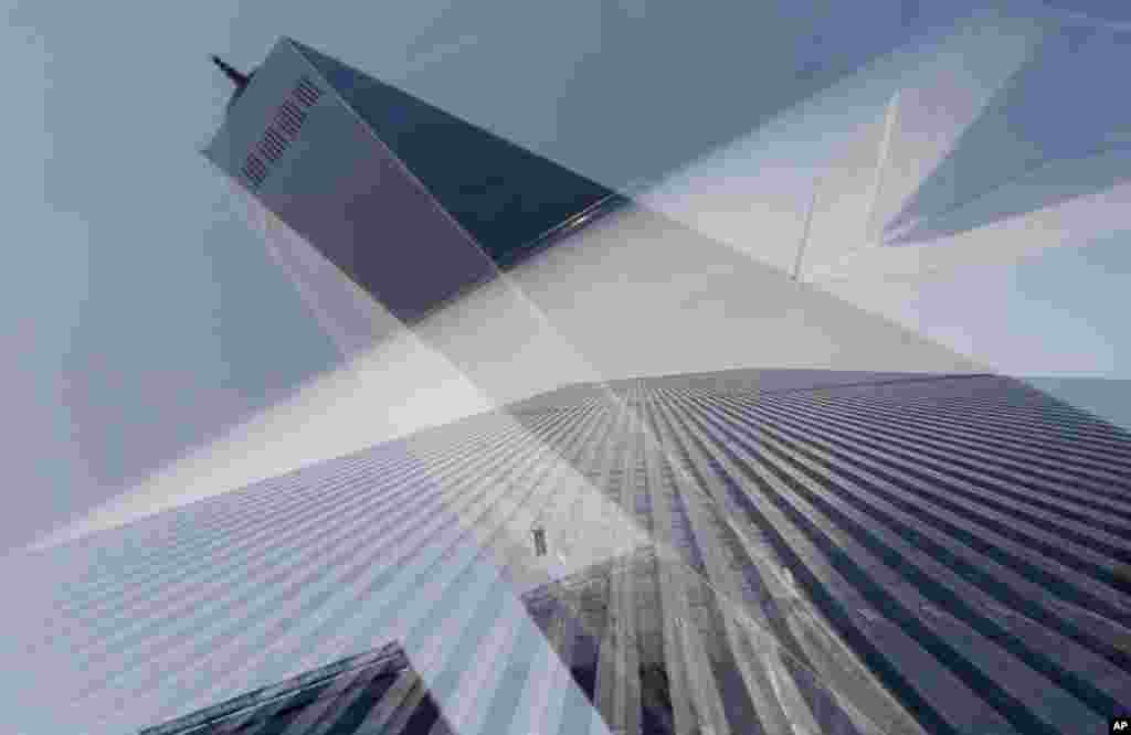 Foto gedung asli World Trade Center ditampilkan di jendela Museum Nasional 11 September, yang juga memantulkan gedung baru One World Center (8/8) di New York. (AP/Mark Lennihan)