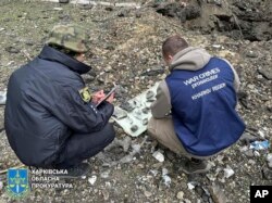 Ratni istražitelji vrše inspekciju fragmenata bombe nakon ruskog napada na Harkov, Ukrajina, 24. aprila 2024.