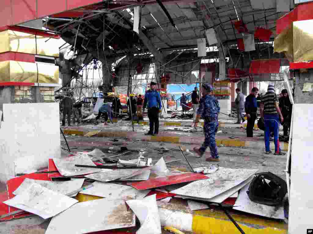 Security forces and civilians inspect the site of a massive bomb attack in Hillah, about 95 kilometers south of Baghdad, Iraq, March 9, 2014.&nbsp;