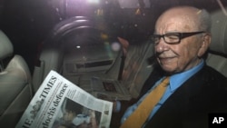 News Corp Chief Executive and Chairman Rupert Murdoch holds a copy of T"he Times" newspaper as he leaves his home in London, England, July 20, 2011. (Reuters)